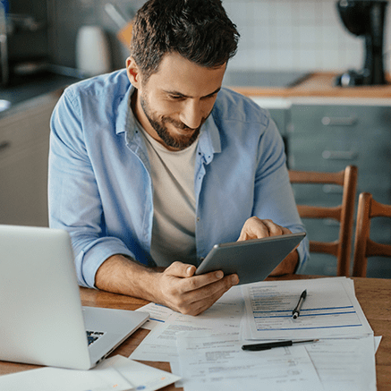 man working at desk with papers and computer